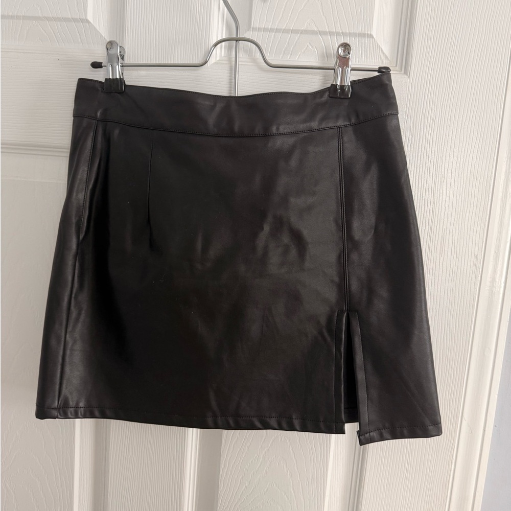 Black faux leather mini skirt with zipper and button details. Size: M